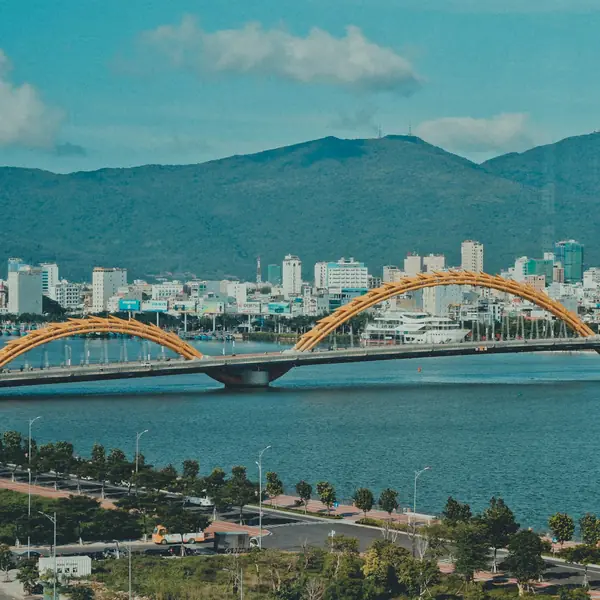 The yellow arches of the Dragon Bridge over the Han River, mountains behind